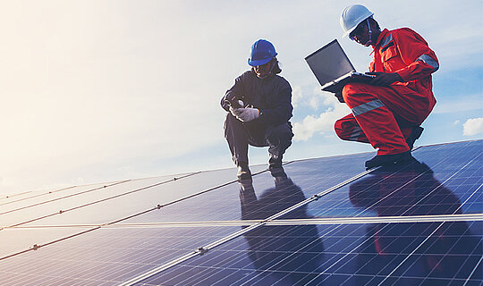 Energy4U Konferenz 2023 - Handwerker stehen auf Solarpanel